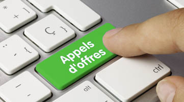 Doigt apuyant sur une touche de clavier marquée "Appels d'offre"